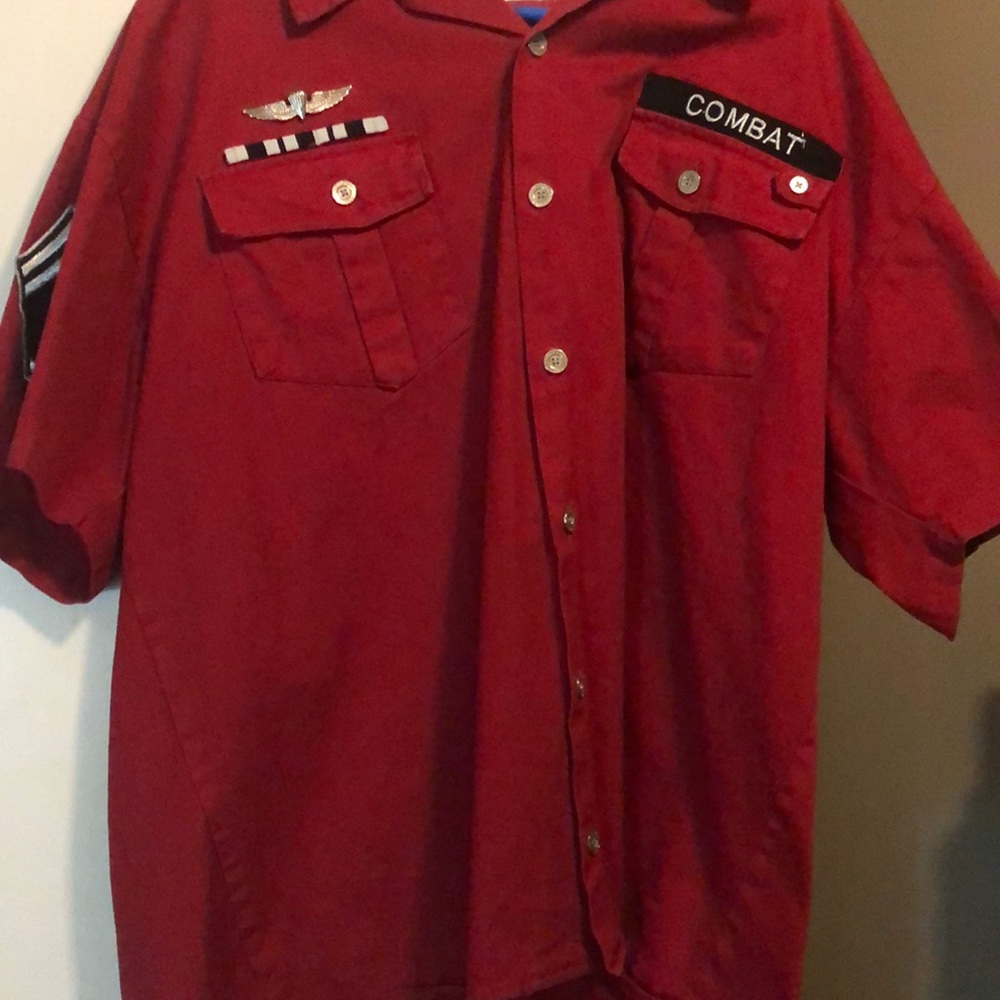 It is a red shirt multiple things and pins on it it has gold buttons